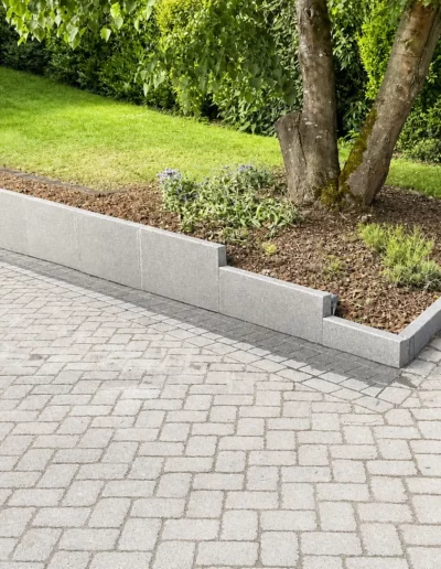 Pflasterfläche mit Randsteinen und Beeteinfassung im Gartenbereich in Ostbelgien